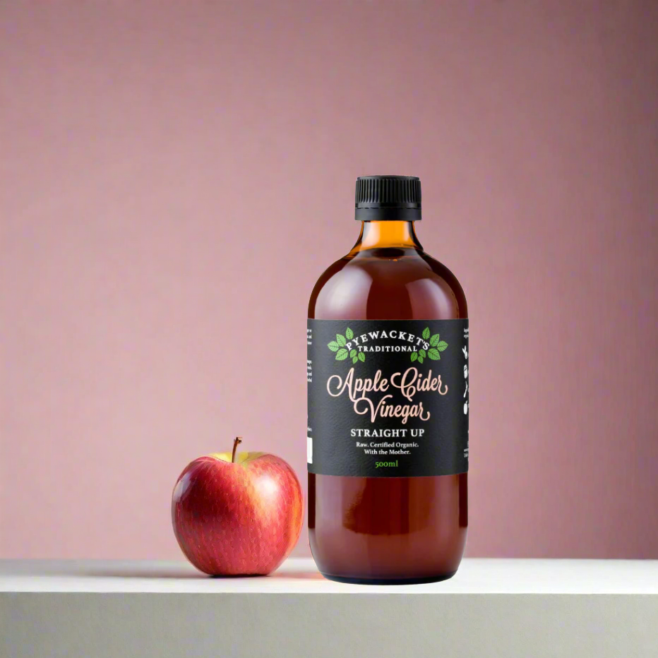 bottle of apple cider vinegar and an apple
