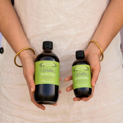 Holding both sizes of verdita detox tonic 